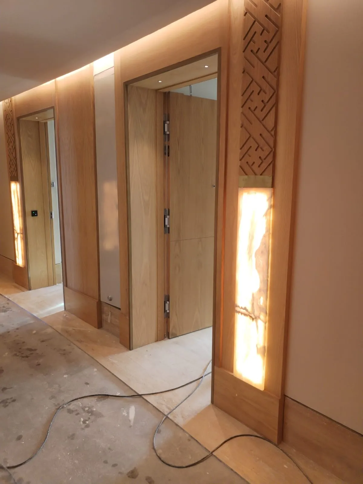 Pasillo del St. Regis Cancún con puertas de madera